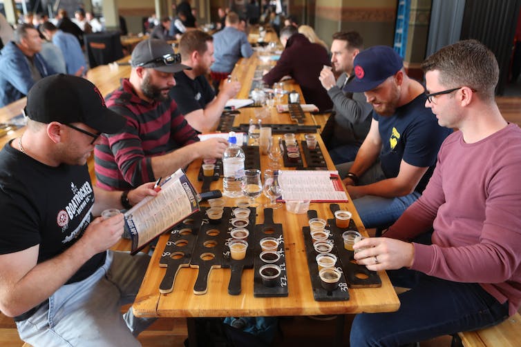 Friends try different beers at a craft beer festival.